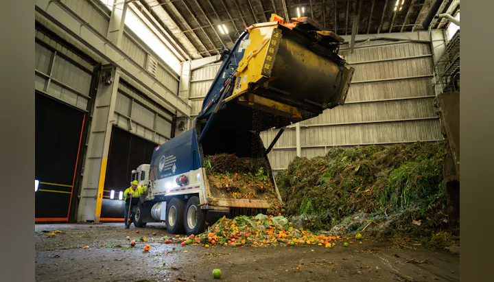 a garbage truck dumps a load of organic waste
