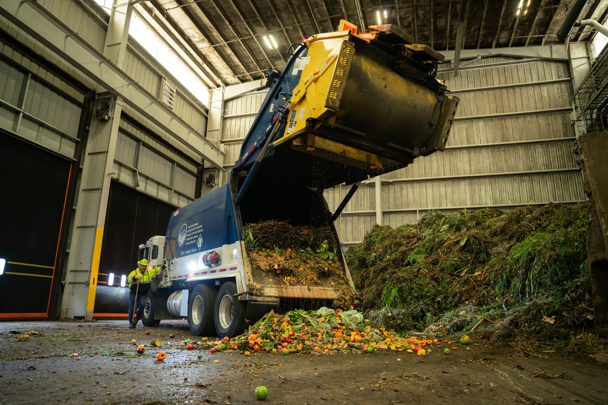 a garbage truck dumps a load of organic waste