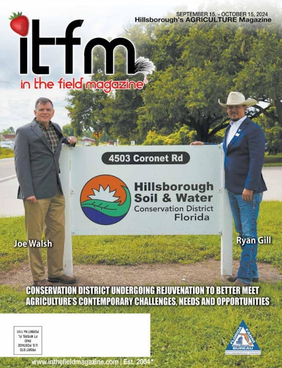 Two men posing by a sign for Hillsborough Soil & Water Conservation District, on the cover of "In the field magazine."