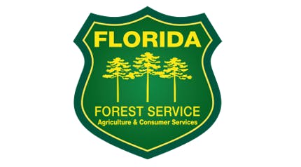 A shield-shaped logo with text "Florida Forest Service" and three trees, indicating it's an emblem of the forestry department.