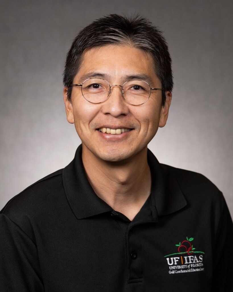 A person wearing glasses and a black polo with a logo that includes "UF IFAS University of Florida" text.