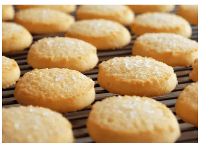 Freshly baked sugar sprinkled cookies cooling on a wire rack.