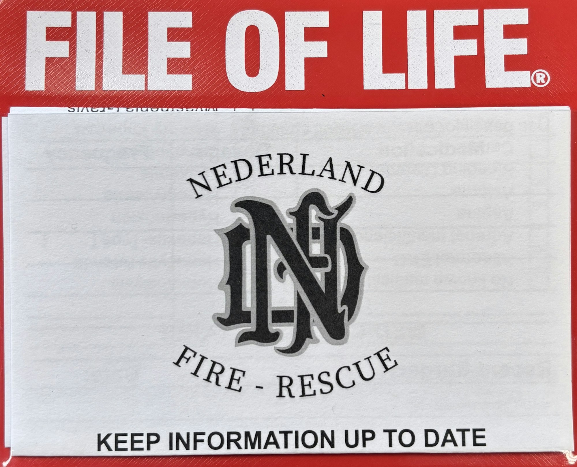 Red booklet titled "FILE OF LIFE" with "NEDERLAND FIRE - RESCUE" and a request to keep information updated.