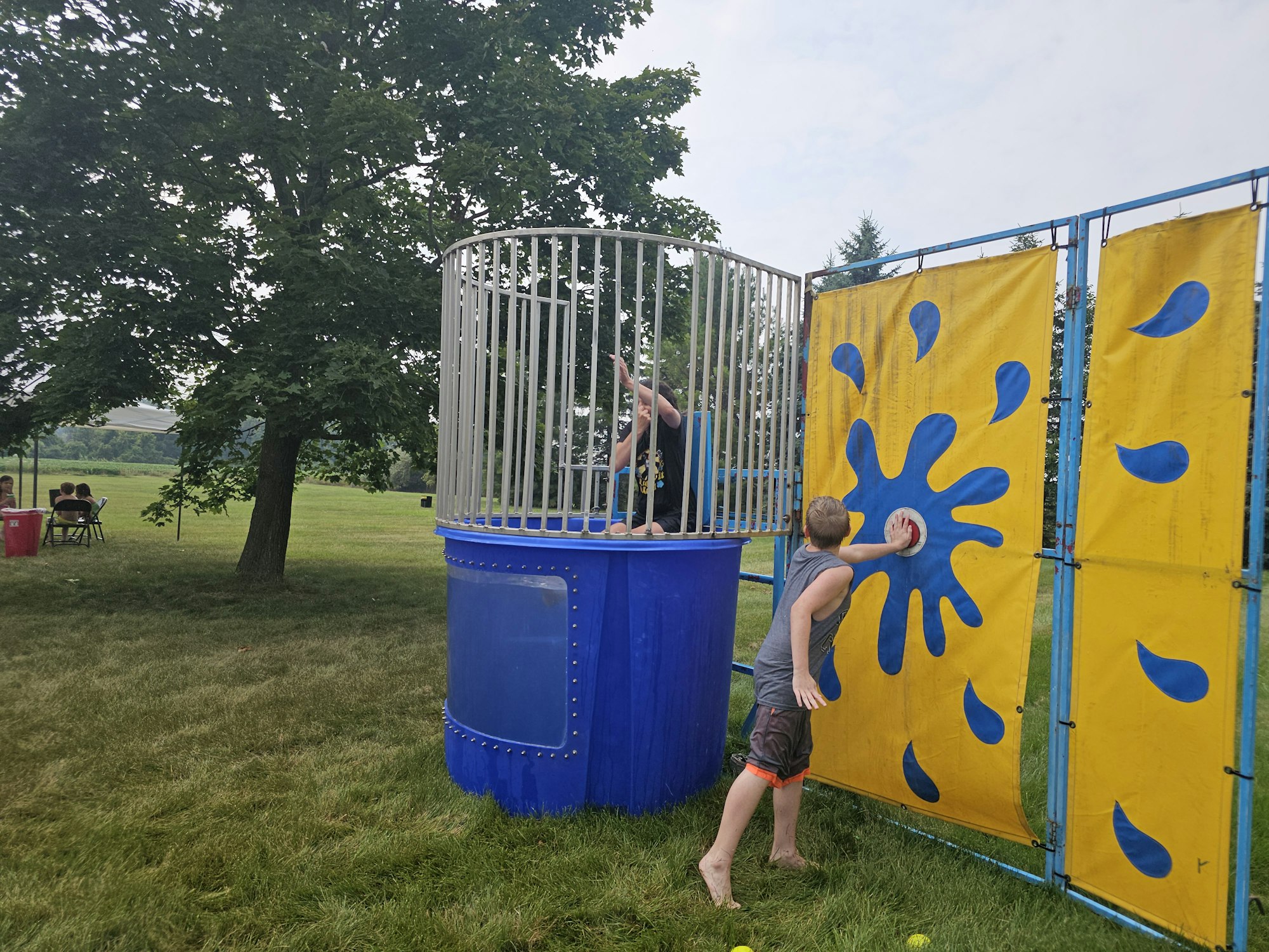 A person aims at a dunk tank target, while another waits inside to be dunked.