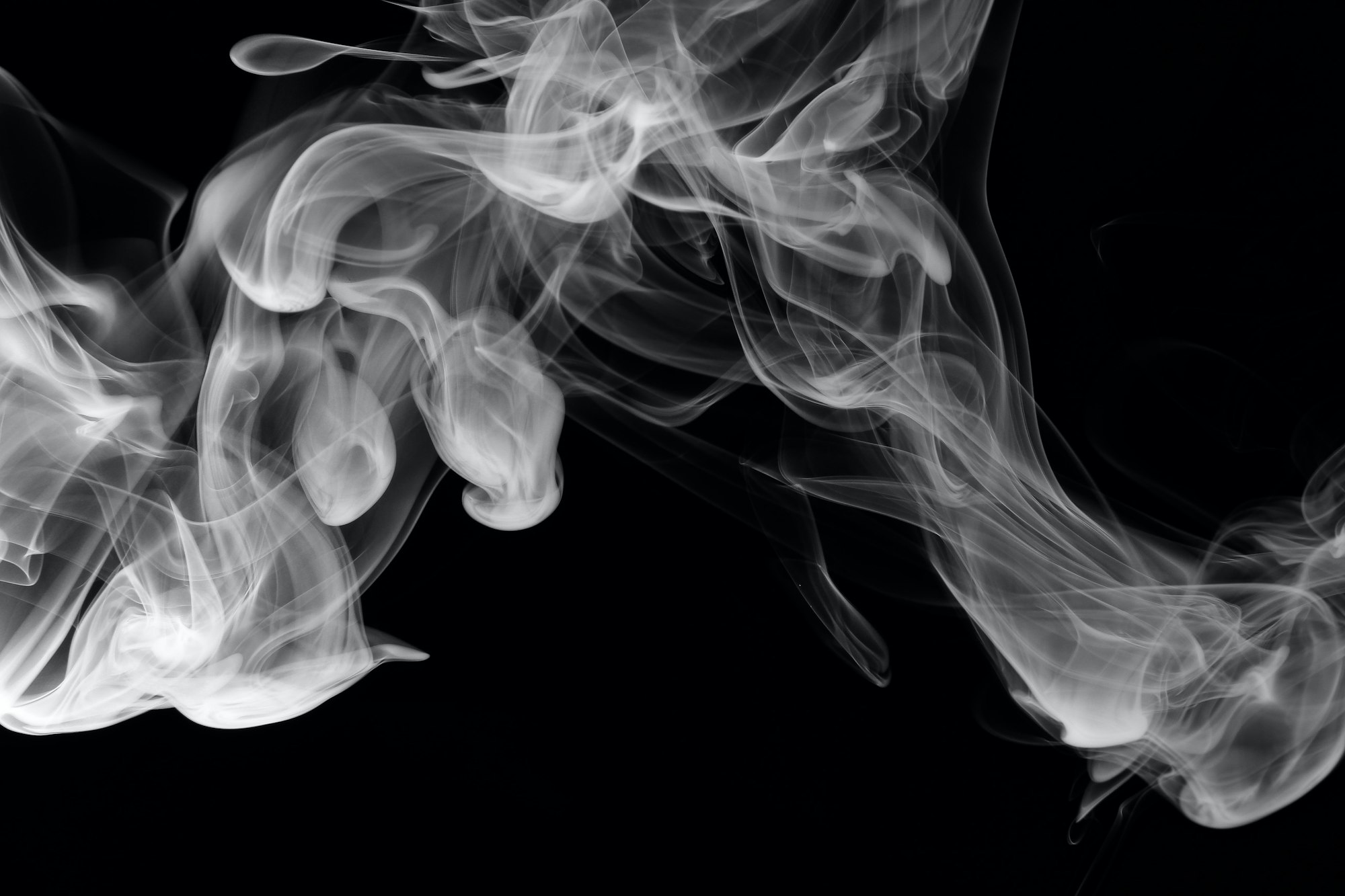 Swirling white smoke patterns on a black background.