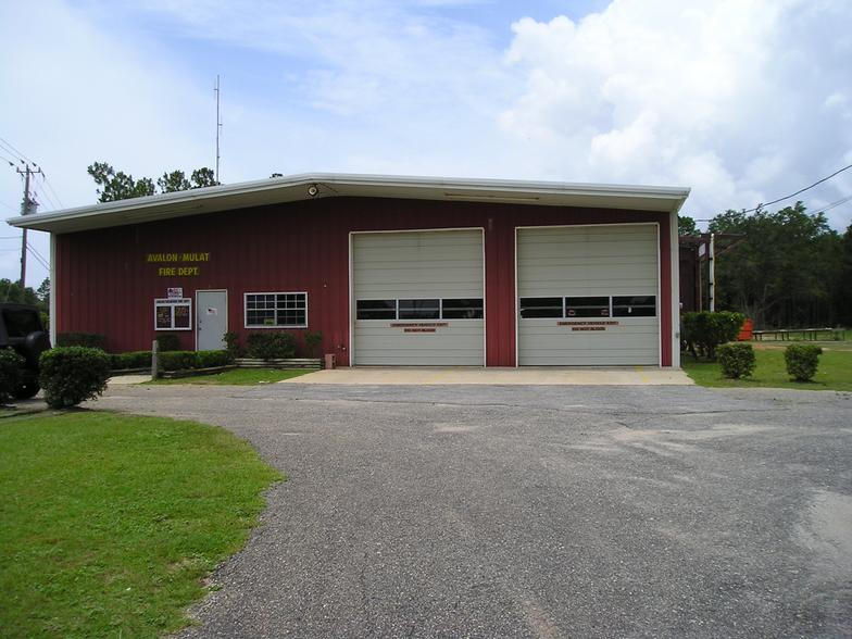 Red fire station with two garage doors and a sign "Avalon-Mulat Fire Dept" above the entrance.