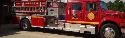 A red fire truck parked outside, Fire Rescue written on it.