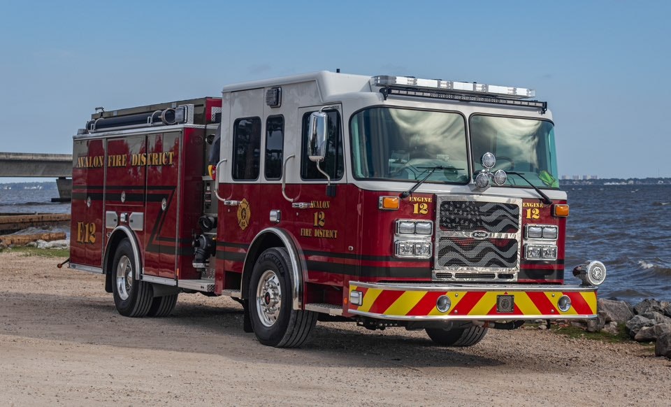 A red fire truck from Avalon Fire District parked by the water, ready for emergencies.
