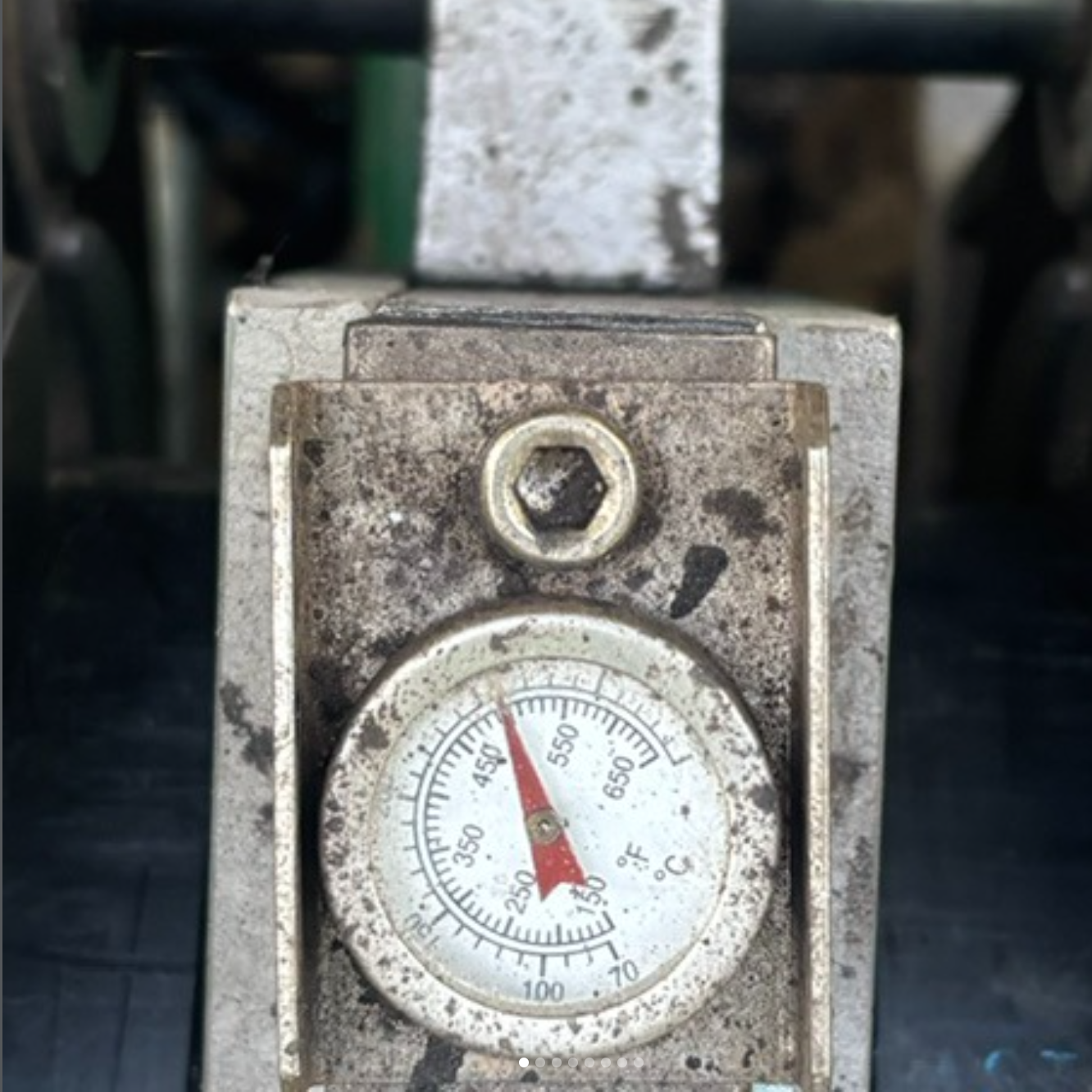The image shows a dirty pressure gauge with a dial indicating measurements, likely used for industrial purposes.