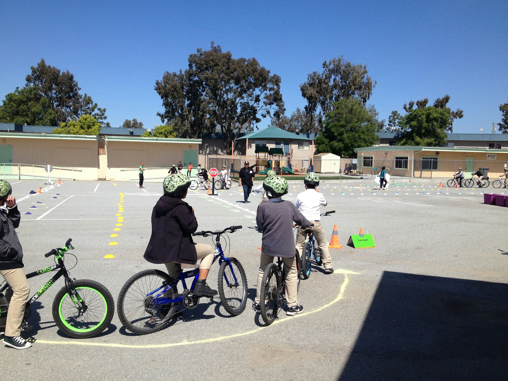 Children with helmets on bicycles at a bike safety training course.