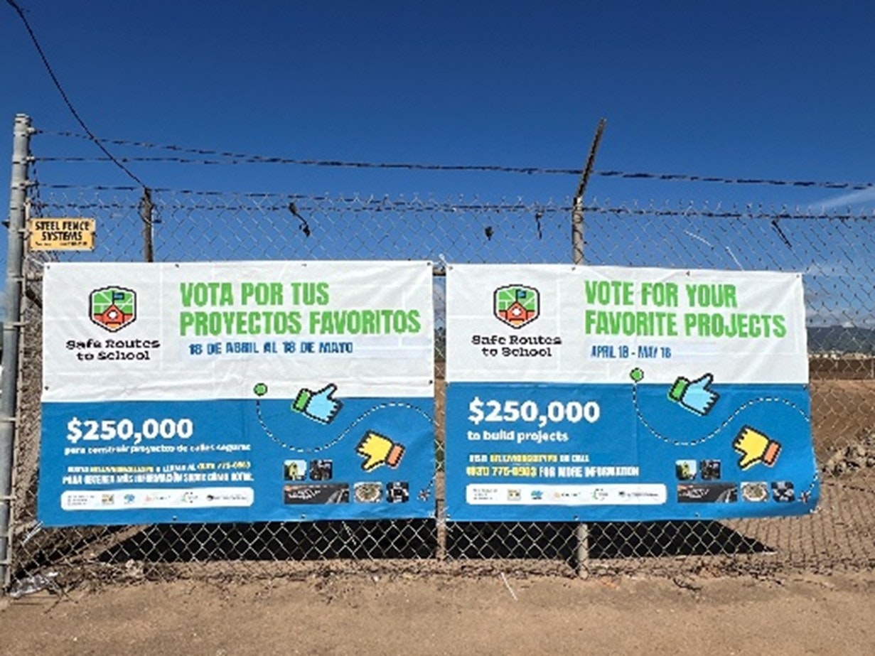 Fence banners promote voting for favorite projects with $250,000 funding for "Safe Routes to School" from April 18 to May 16.
