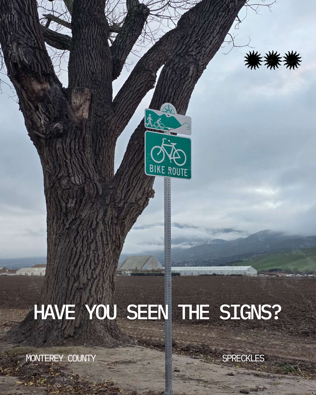The image features a tree and a sign indicating a bike route in Monterey County, with the text "HAVE YOU SEEN THE SIGNS?"
