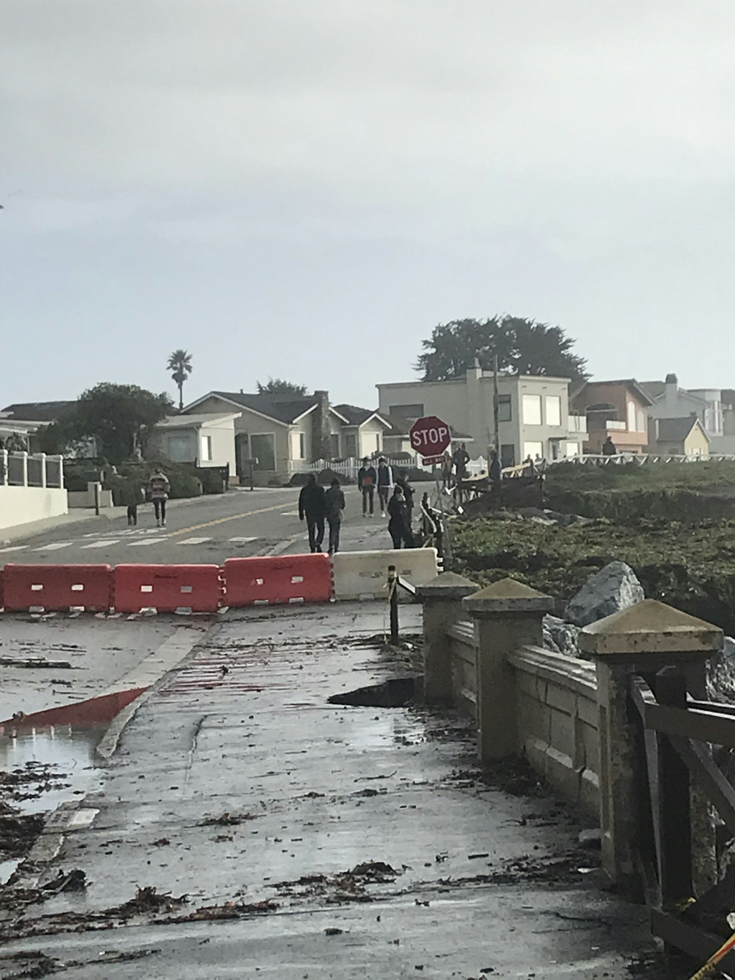 flooded street and people along  shoreline