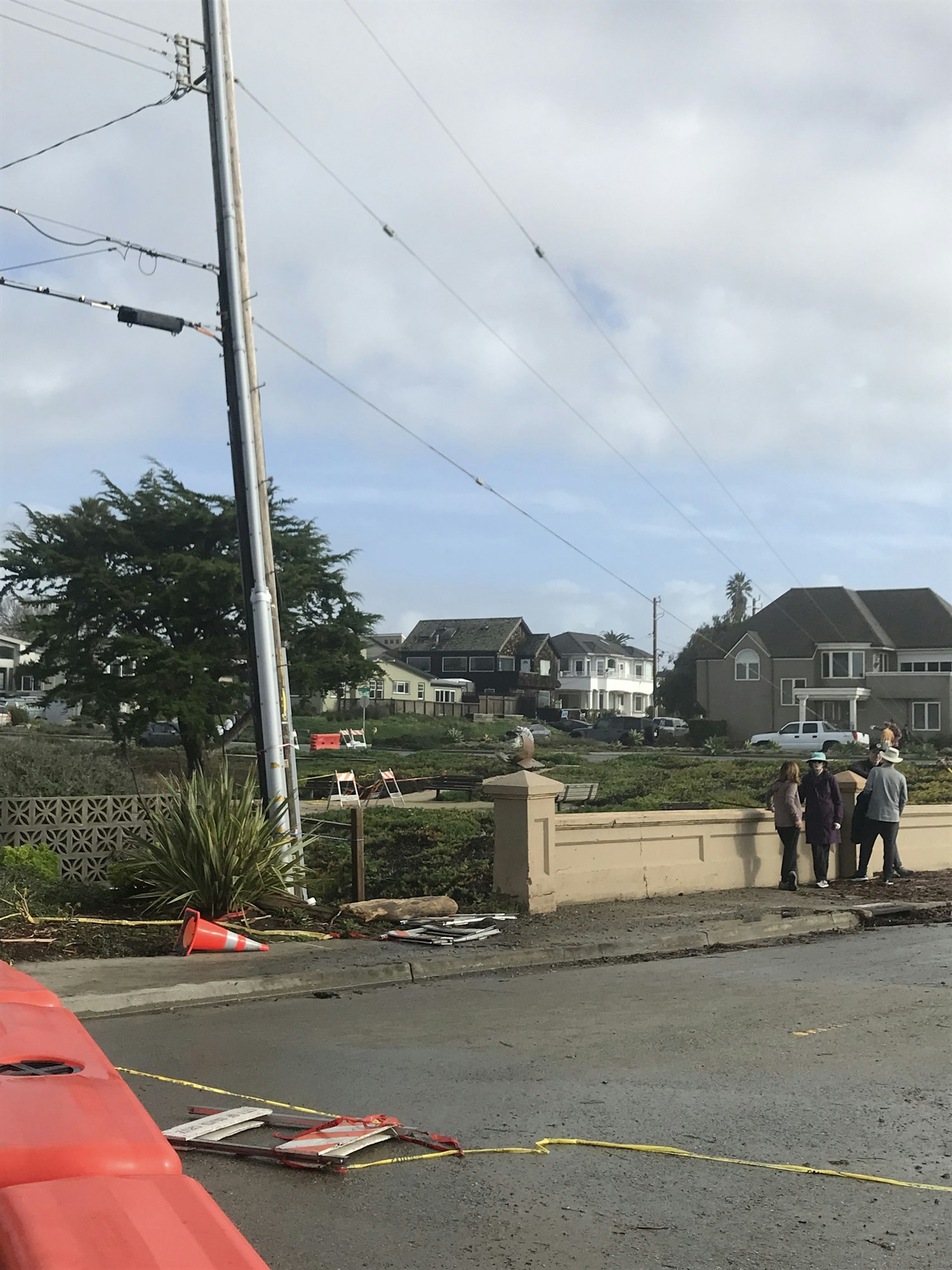 People walking along a sidewalk near a street construction site