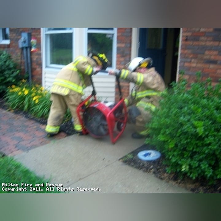 Photo of firefighters with a fan