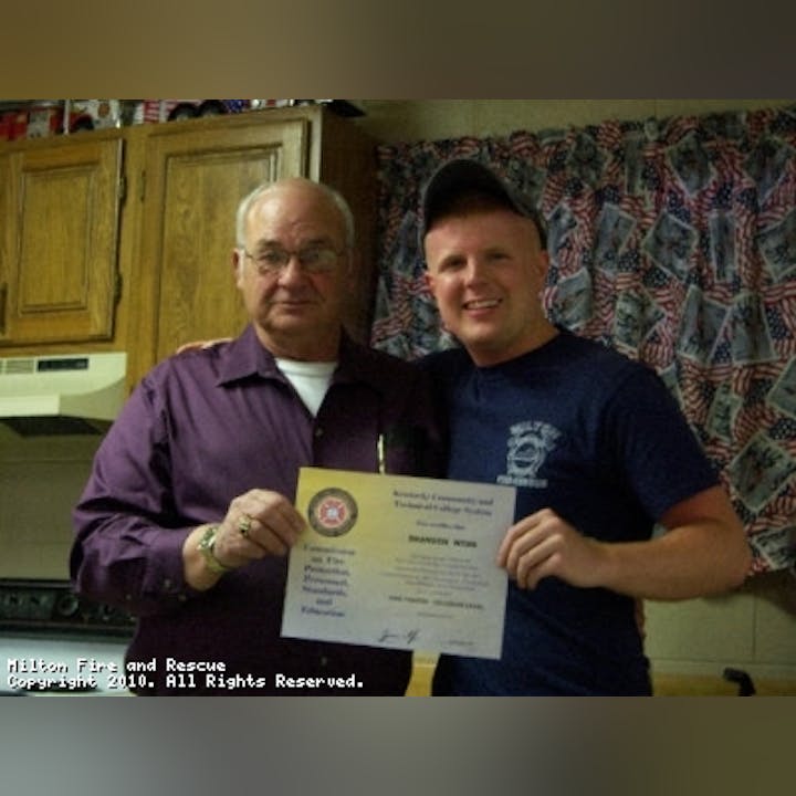 Photo of two people holding an award or certificate