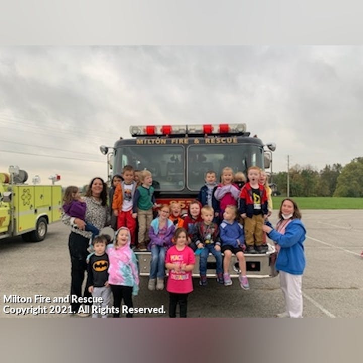 Photo of people posing in front of a fire engine