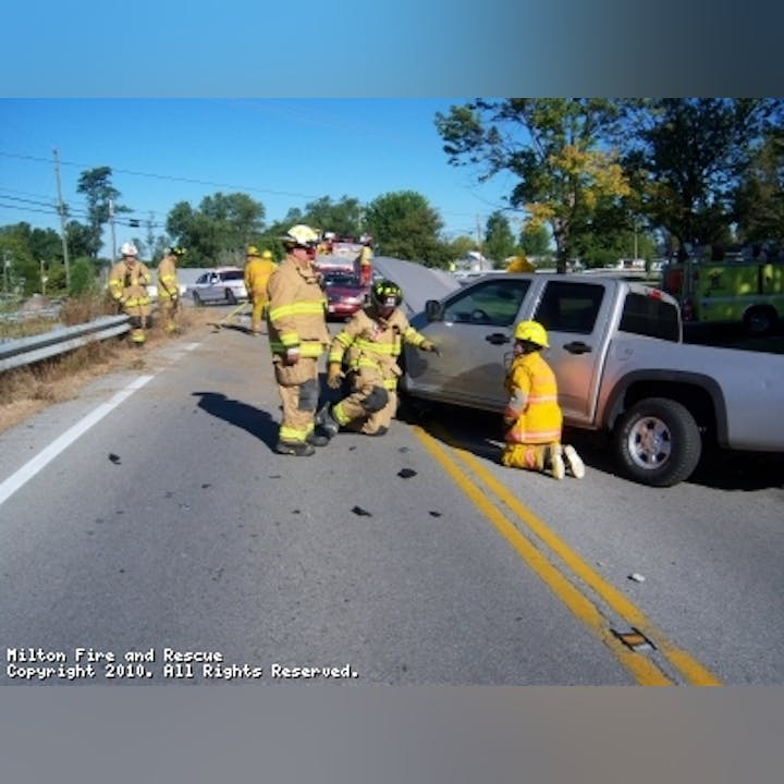Photo of firefighters and a gray disabled truck