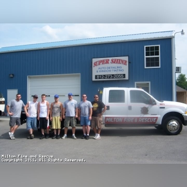 Photo of people gathered in front of a truck