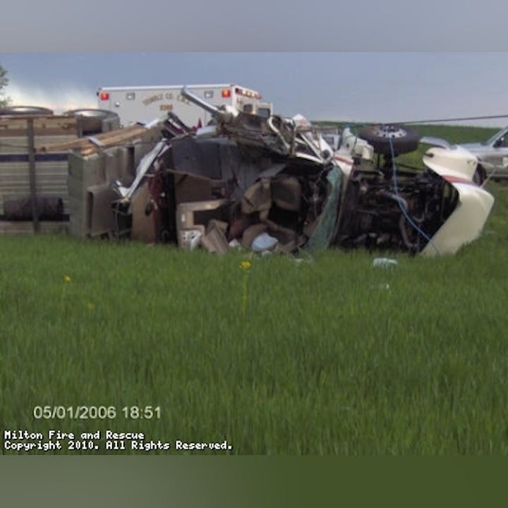 Photo of a semi truck turned over in a field