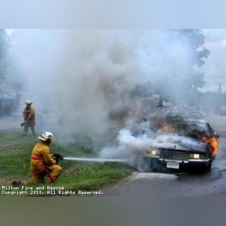 Photo of firefighters putting out a car fire