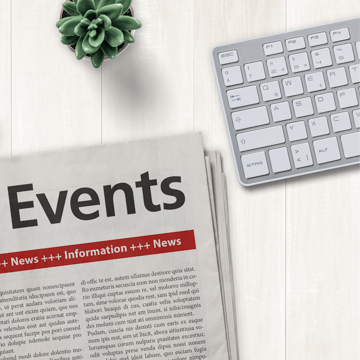 A newspaper with "Events" headline, a keyboard, and a potted succulent on a white surface.
