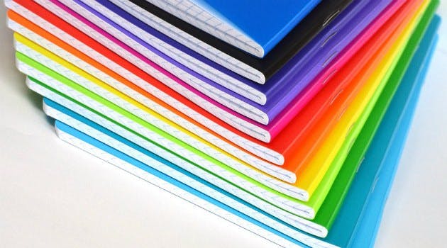 A stack of colorful notebooks arranged in a staggered stack.