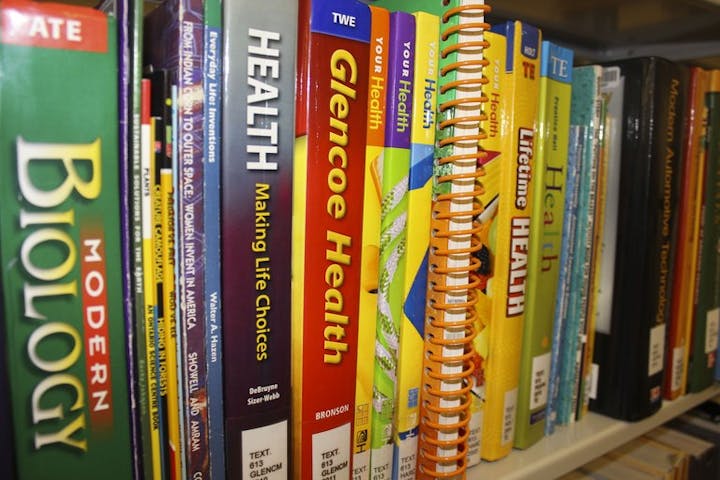 Books on a shelf with titles about health, biology, and lifestyle choices.