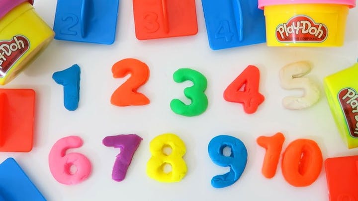 Colorful Play-Doh numbers 1-10 with matching molds and Play-Doh containers displayed on a white surface.
