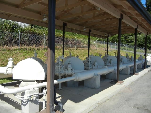 A row of pipes and machinery under a balcony
