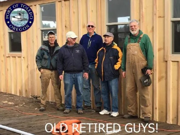 Five men standing in front of a wooden building under construction with "OLD RETIRED GUYS!" text below.