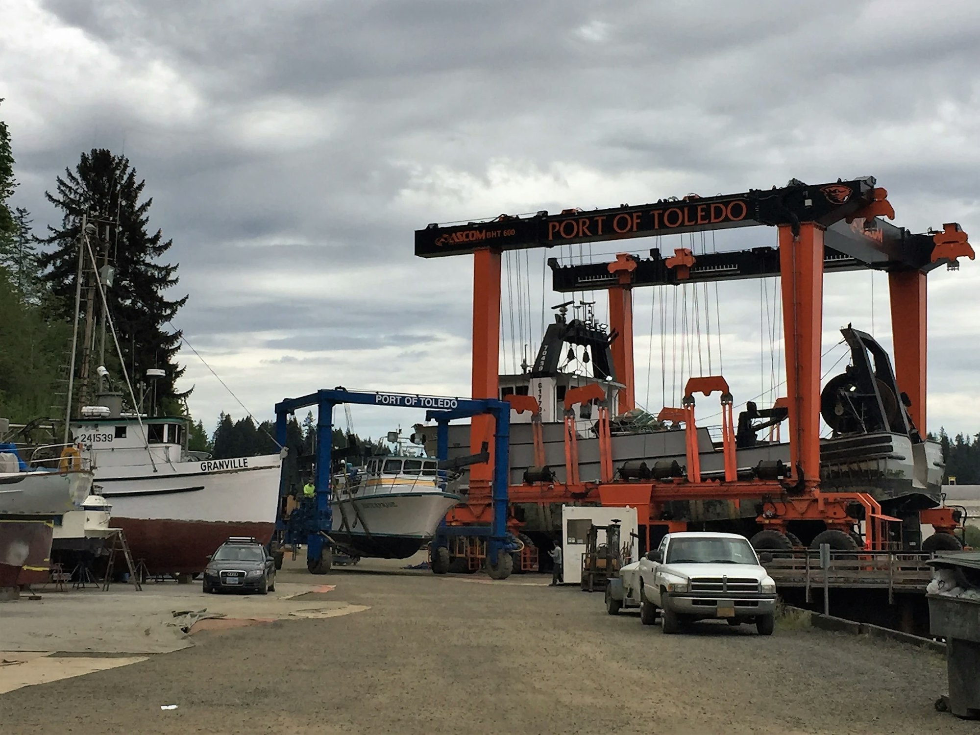 Boats in a dry dock with a large gantry crane labeled "PORT OF TOLEDO."
