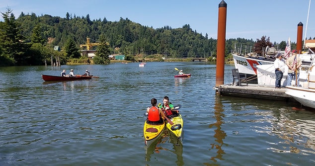 A sunny day on the water with kayakers and boaters enjoying the outdoors.