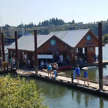 A waterfront building with people on a floating dock on a sunny day.