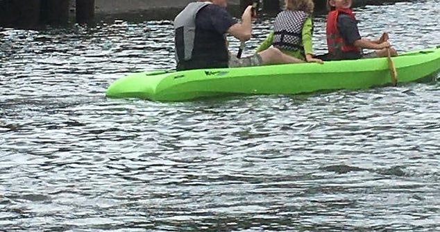 People on a green kayak in the water.