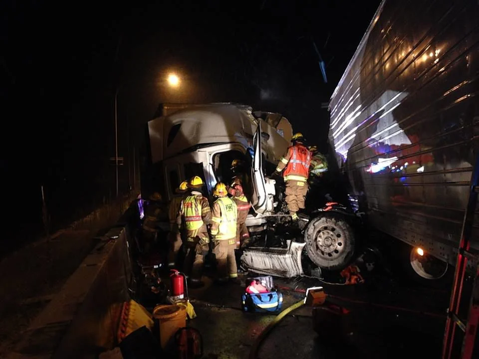 Firefighters respond to a nighttime truck accident scene.