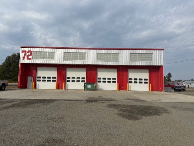 A red and white building with four garage doors, marked "72," likely a fire station or service facility.