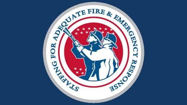 Emblem with two firefighters and the text "Staffing for Adequate Fire & Emergency Response."