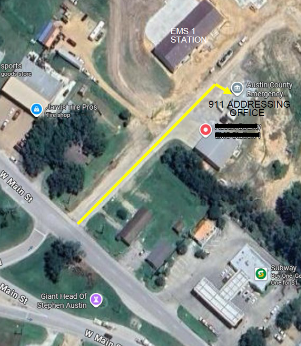 Aerial view showing EMS Station, 911 Addressing Office, various businesses, and yellow path on W Main St.