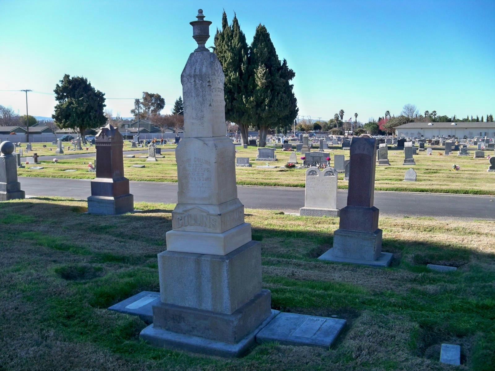 A cemetery with various tombstones under a clear blue sky.