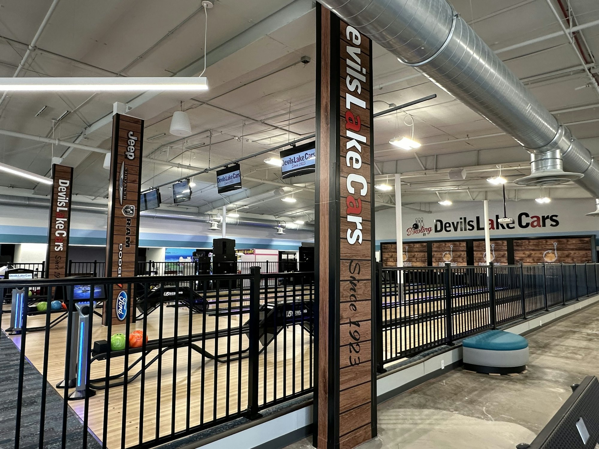 Indoor bowling alley with signs of car brands, possibly a themed automotive dealership with leisure facilities.