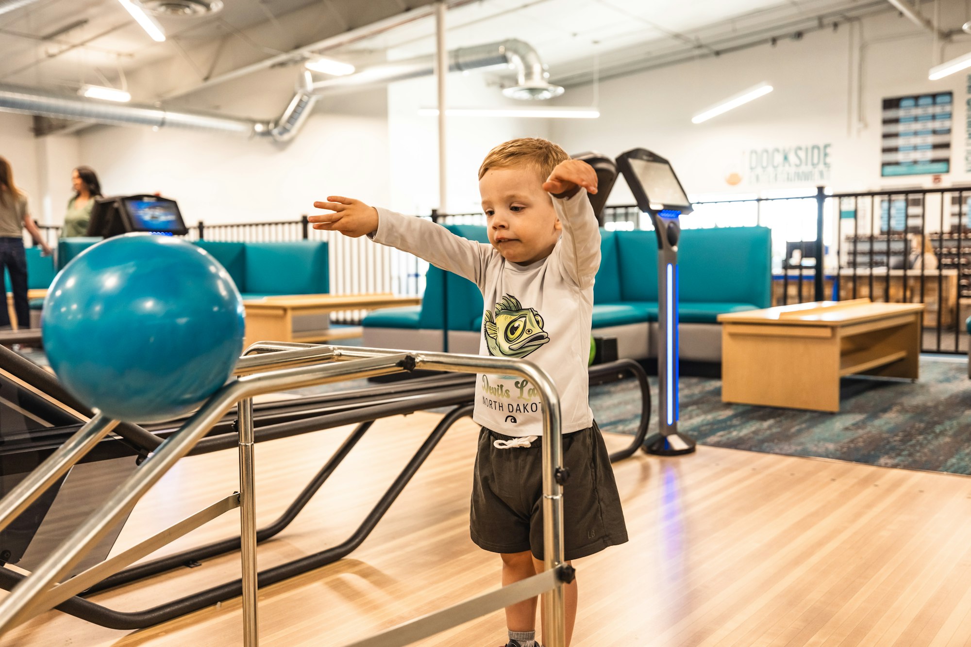 A child bowling with ramps in a bowling alley.