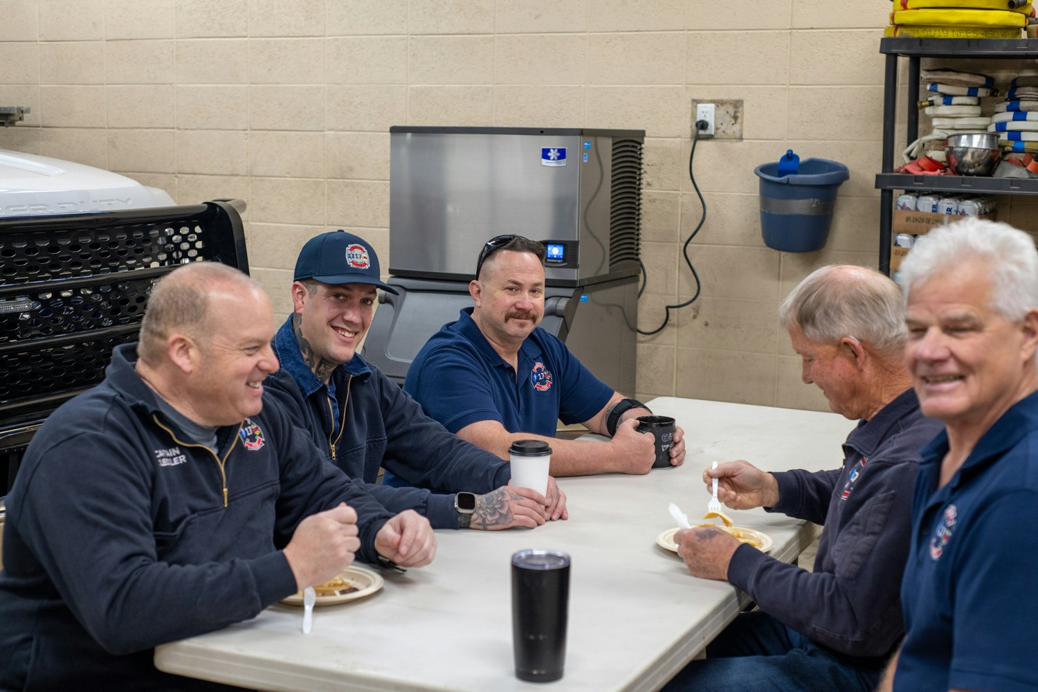 Group of firefighters enjoying a meal and conversation together.