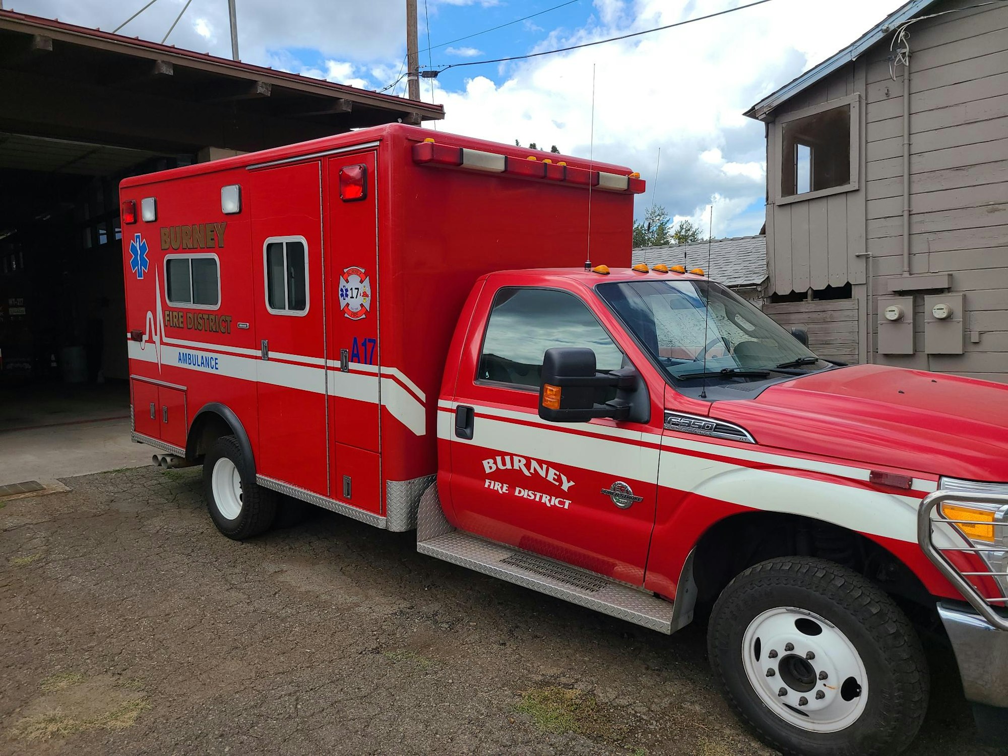 A red ambulance parked outside with "BURNEY FIRE DISTRICT" markings.