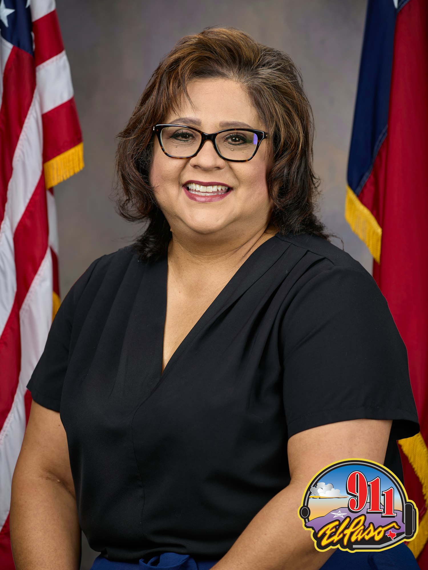 A smiling woman in front of the US and Texas flags, with a "911 El Paso" badge on the image.