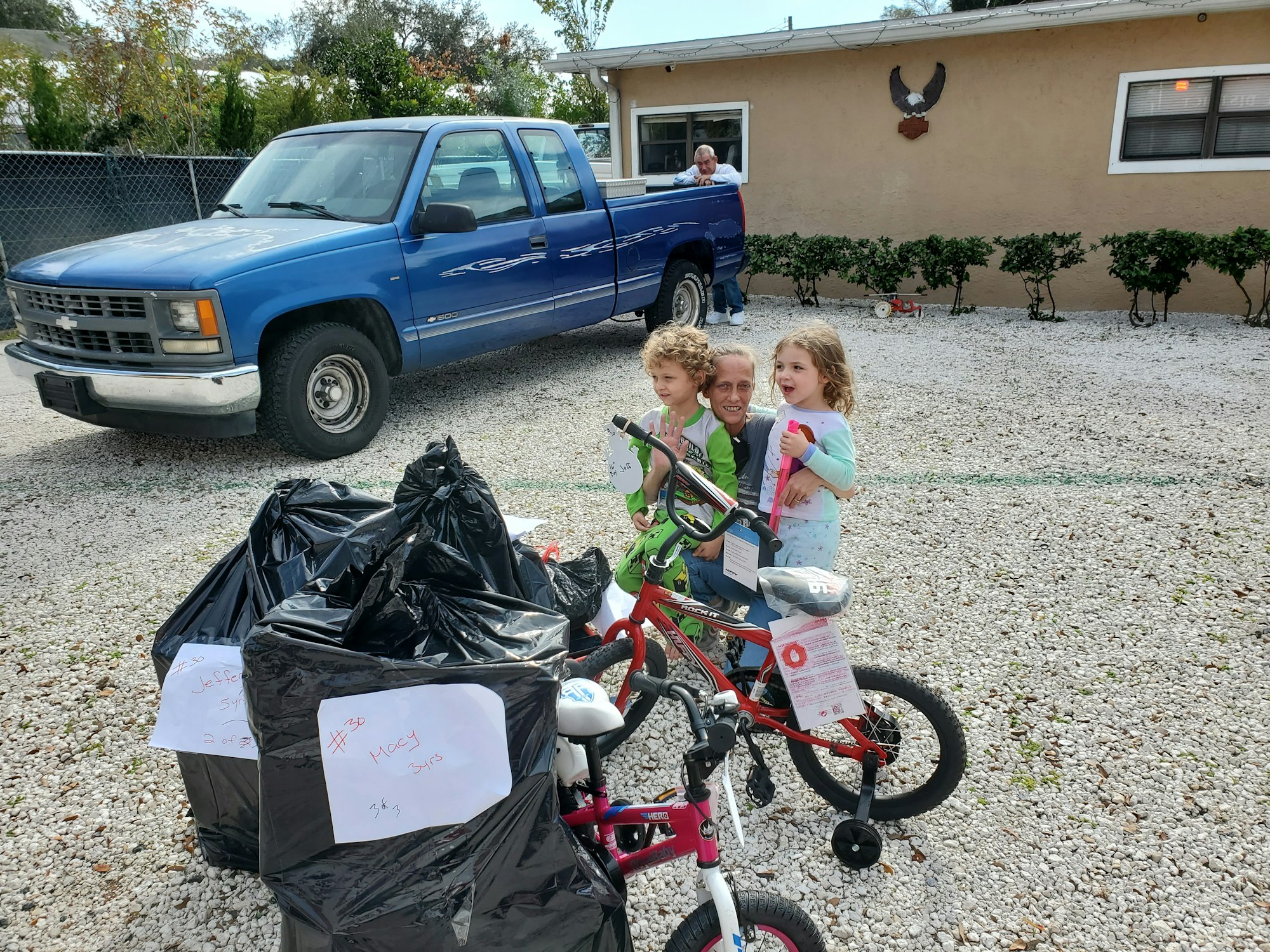 Two little girls and their grandmother receiving their delivery from Santa