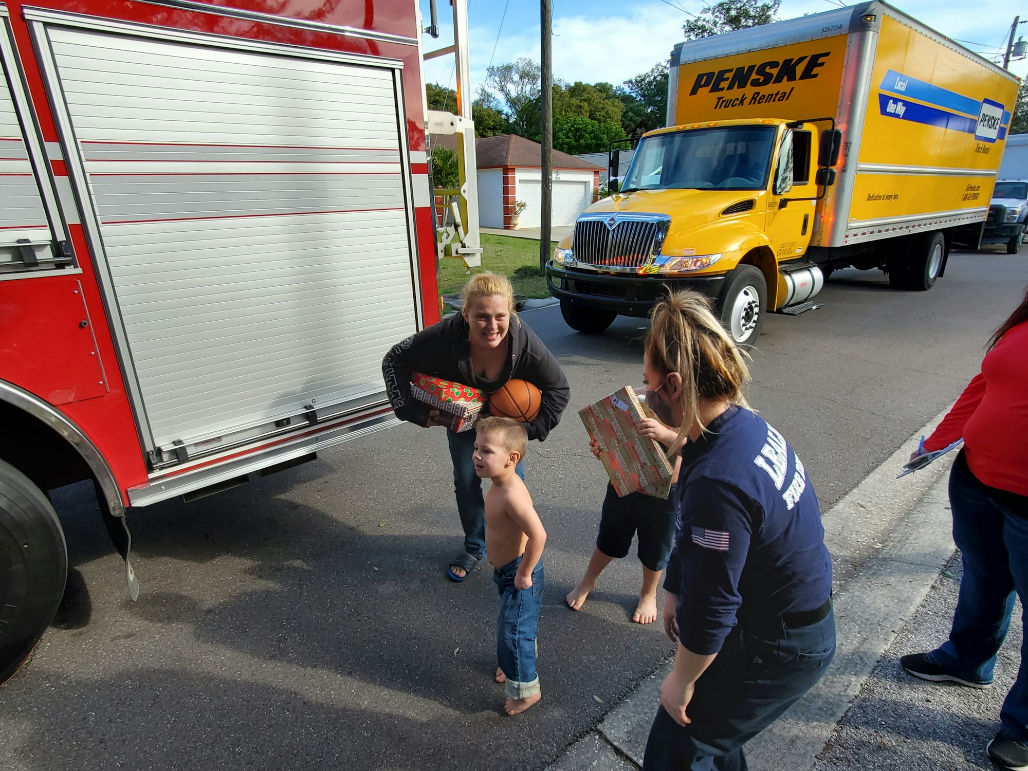 Trucks, firefighter, woman, and two little boys