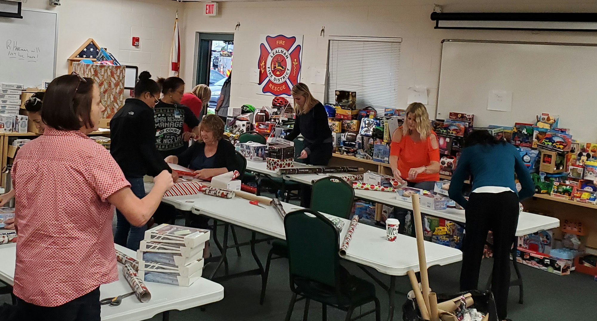 Several people wrapping gifts for delivery