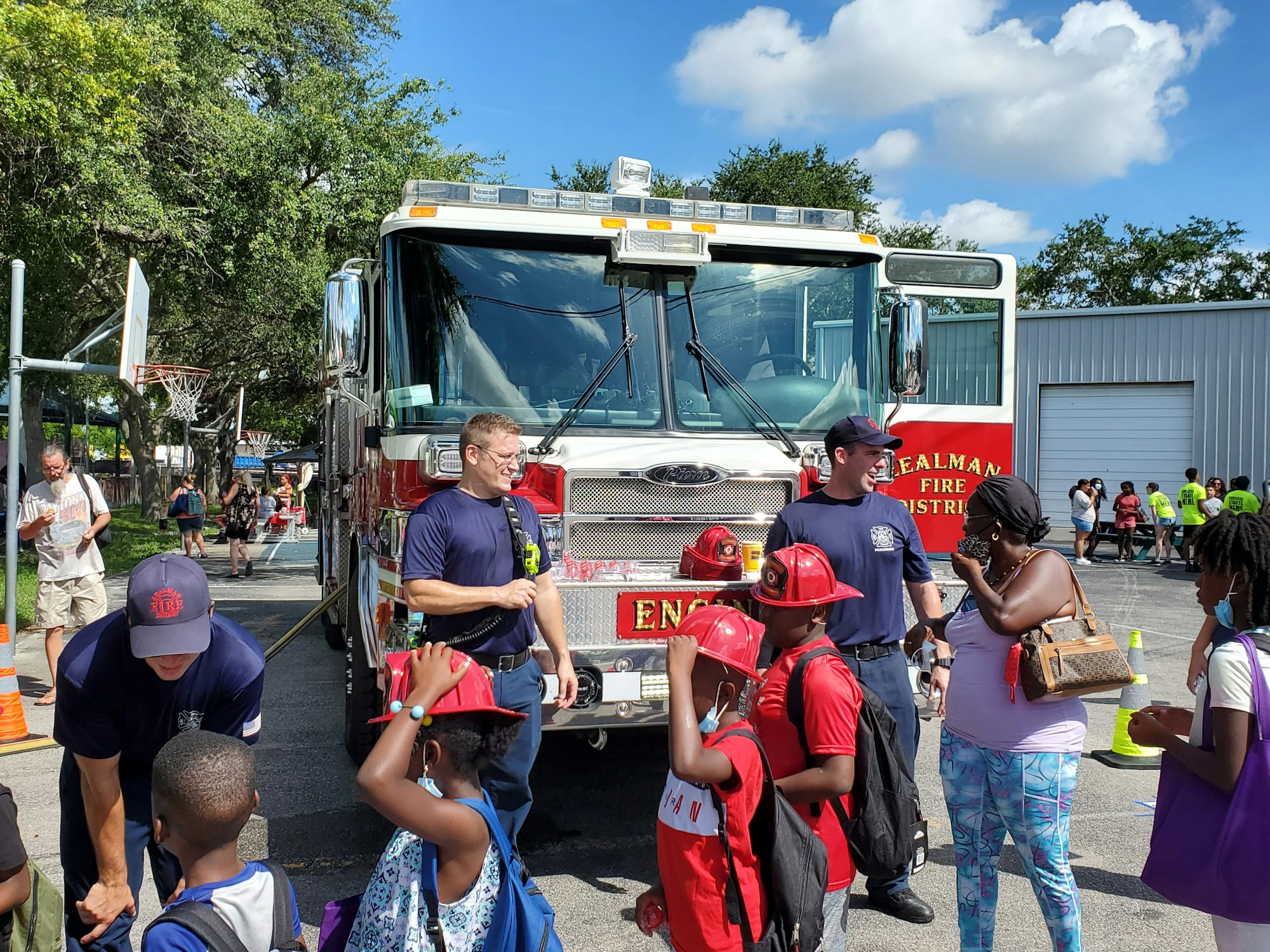 Firefighters talking with kids in front of a fire truck 08/07/2021