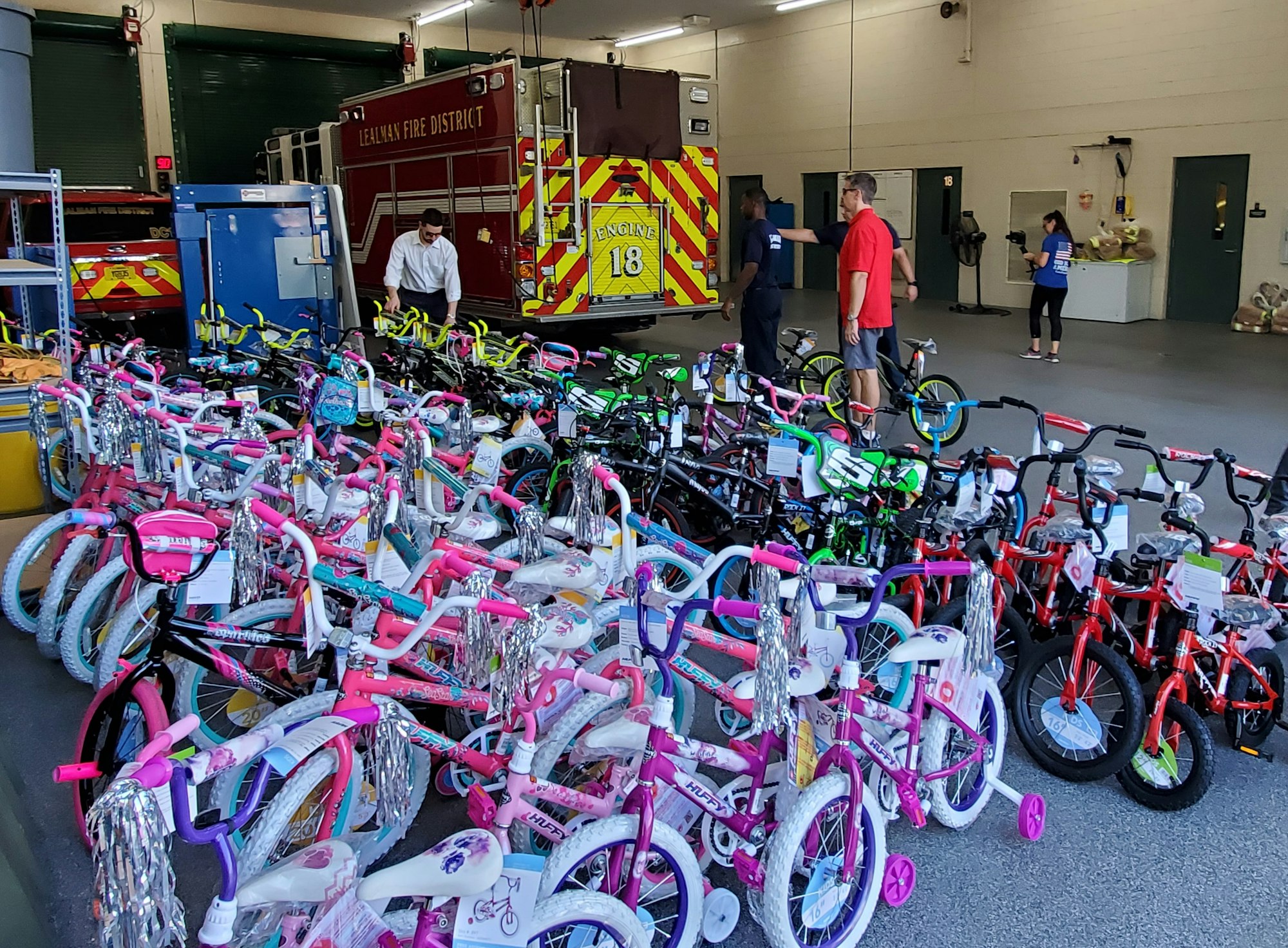 Picture of Bikes inside Fire Station 18 with people, and fire engine